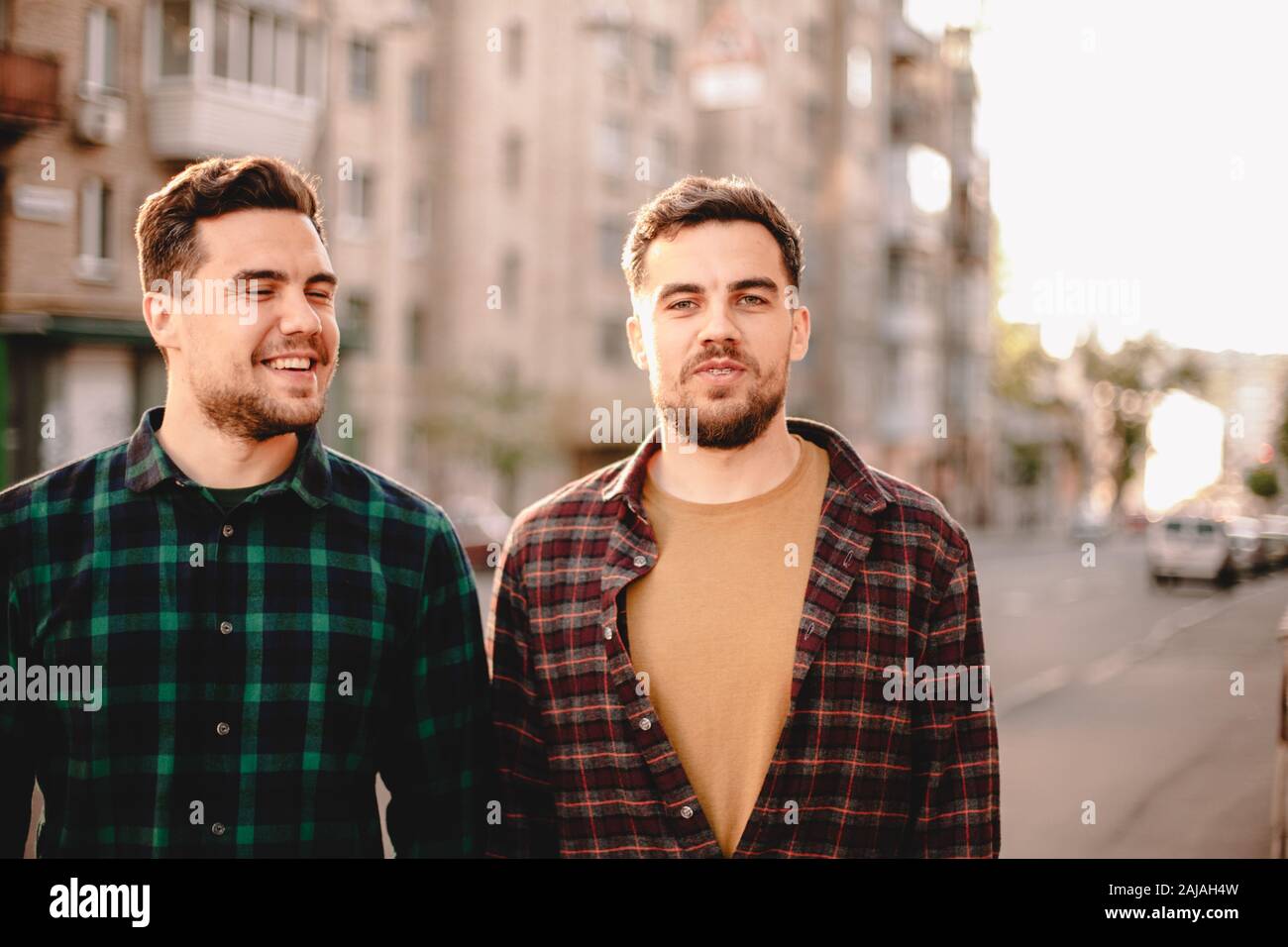 Portrait de frères jumeaux heureux debout dans la rue de la ville pendant l'été Banque D'Images