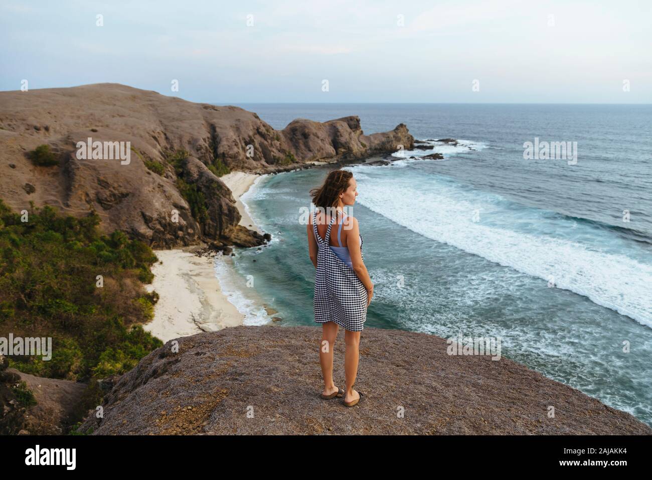 Jeune femme qui séjourne à la colline et regarde la vue Banque D'Images