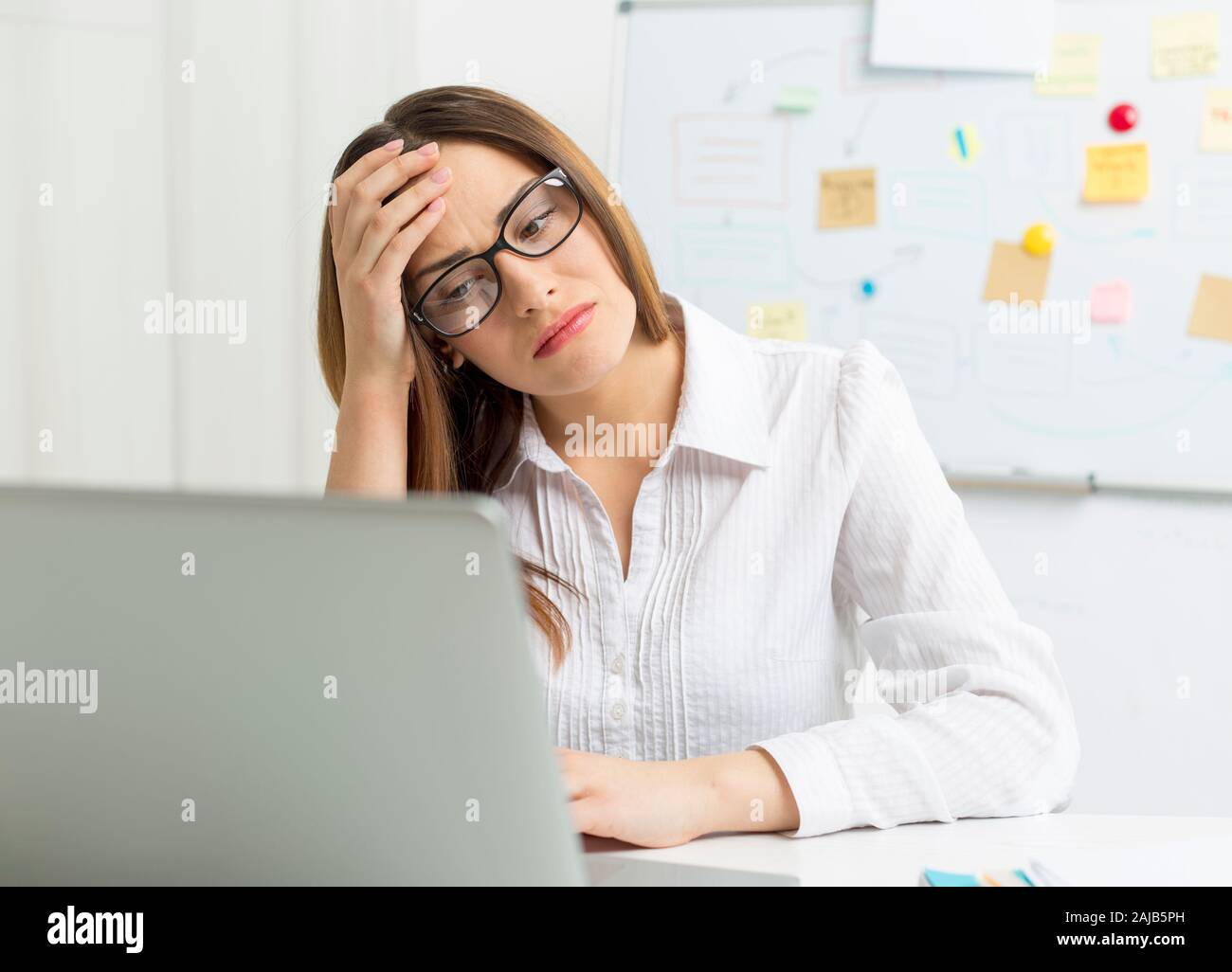 Femme fatiguée au travail à l'ordinateur. Maux De Tête. Banque D'Images