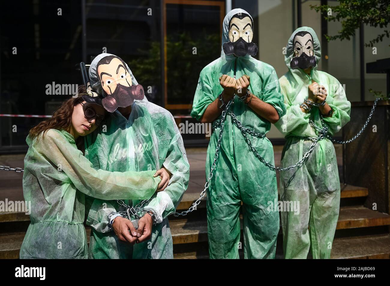 Turin, Italie - 19 juillet, 2019 : activistes du climat montrent qu'ils se lier avec des chaînes en face d'une banque Unicredit portant des masques inspirés par l'argent série Heist ('La casa de papel") diffusée par Netflix. Activistes du climat à partir de vendredi pour l'avenir et l'extinction des groupes de rébellion protester contre les investissements des banques dans les combustibles fossiles. Credit : Nicolò Campo/Alamy Live News Banque D'Images