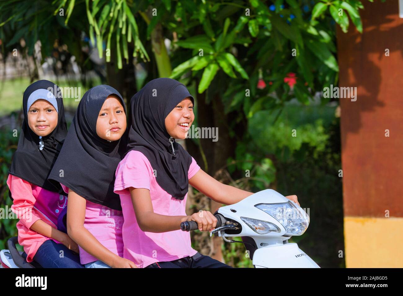 Famille sur une petite moto japonaise sur une route de l'île de Tioman, Malaisie Banque D'Images