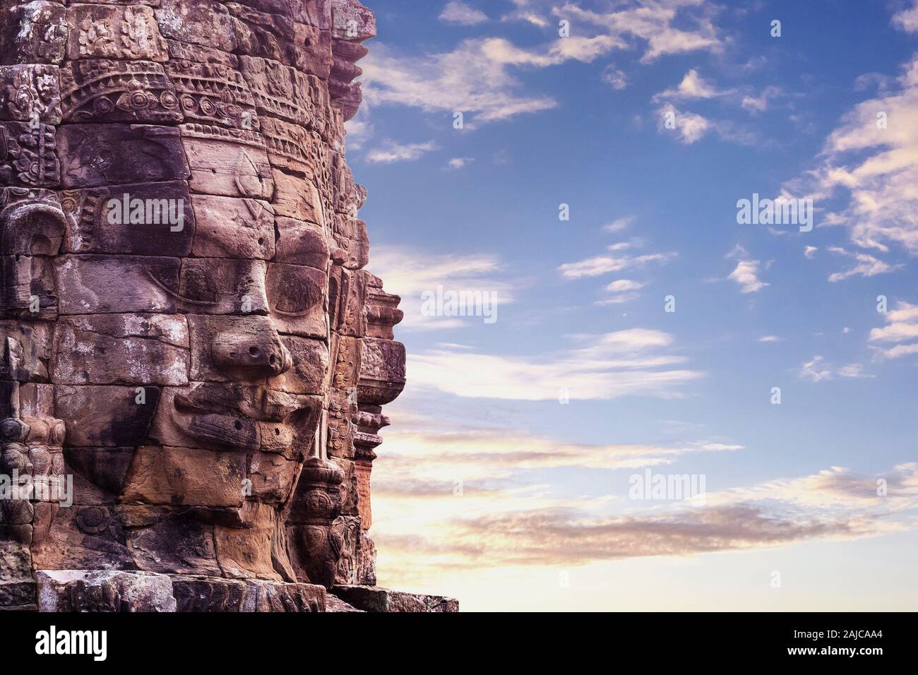 Stone face à ancient temple Bayon au coucher du soleil, Angkor, Siem Reap, Cambodge. Banque D'Images