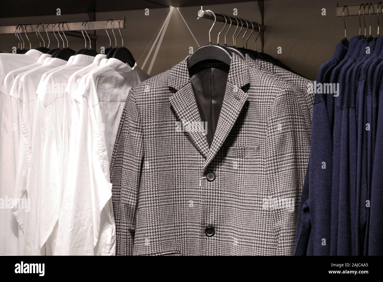Des vêtements décontractés pour hommes en magasin, des vestes, chemises, gilets sur cintres Banque D'Images