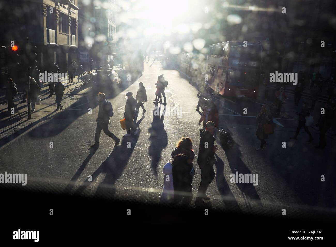 Vue sur les piétons qui traversent une route à Londres à la recherche dans l'éblouissement du soleil de l'étage supérieur d'un bus à impériale est de Londres UK KATHY DEWITT Banque D'Images