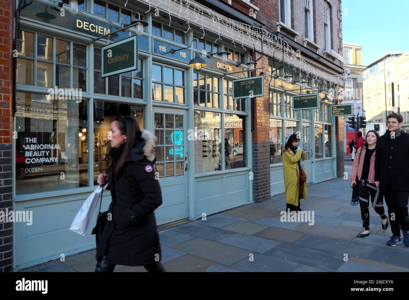 Les gens passant devant les acheteurs boutiques de la rue Commercial à Spitalfields East London E1 England UK KATHY DEWITT Banque D'Images