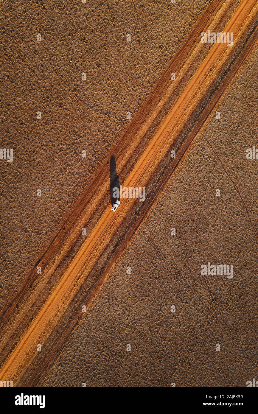 Vue aérienne de la voiture sur une piste du désert australien typique. Banque D'Images