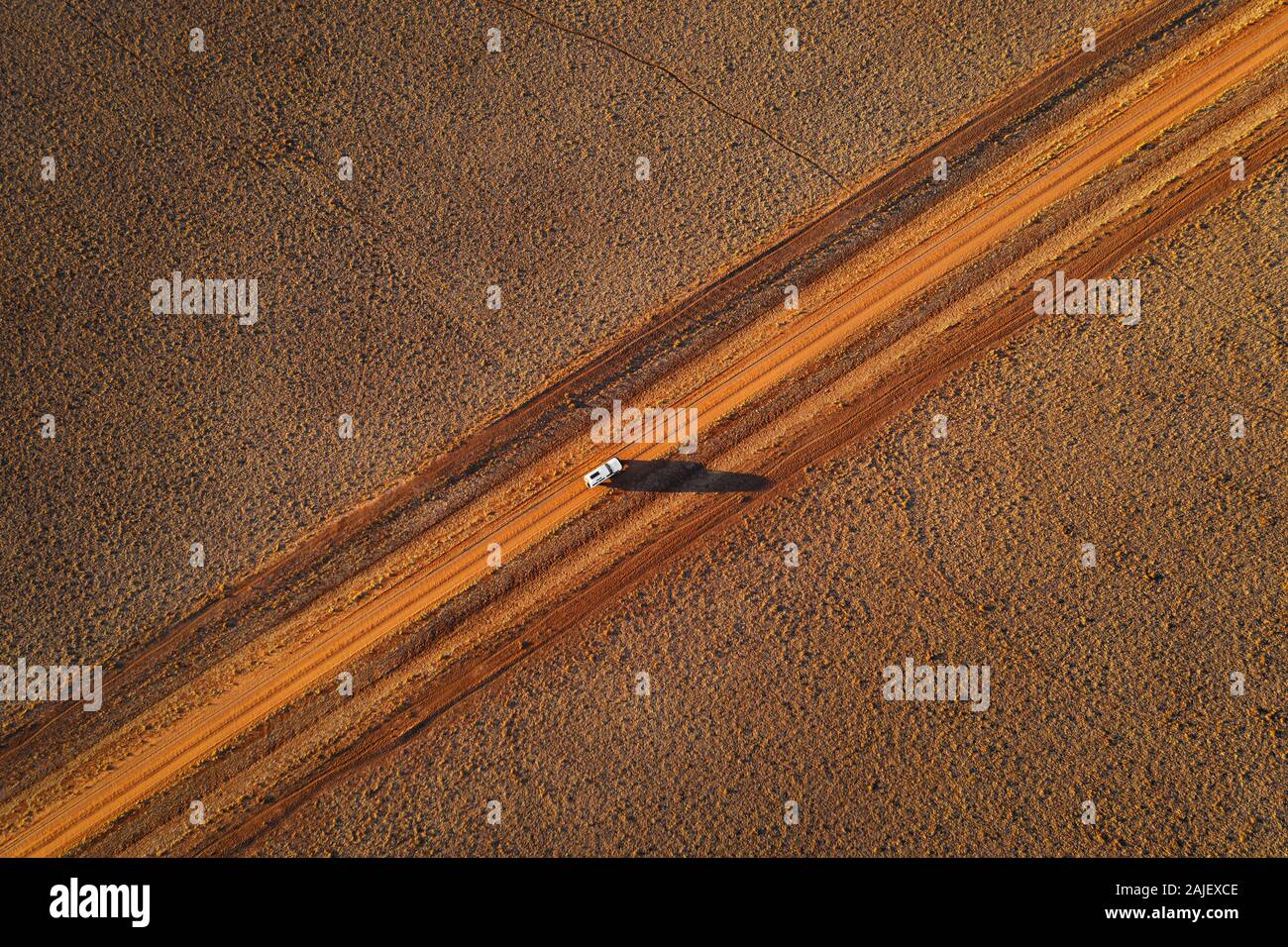 Voiture sur une piste désertique à distance dans l'Outback australien. Banque D'Images