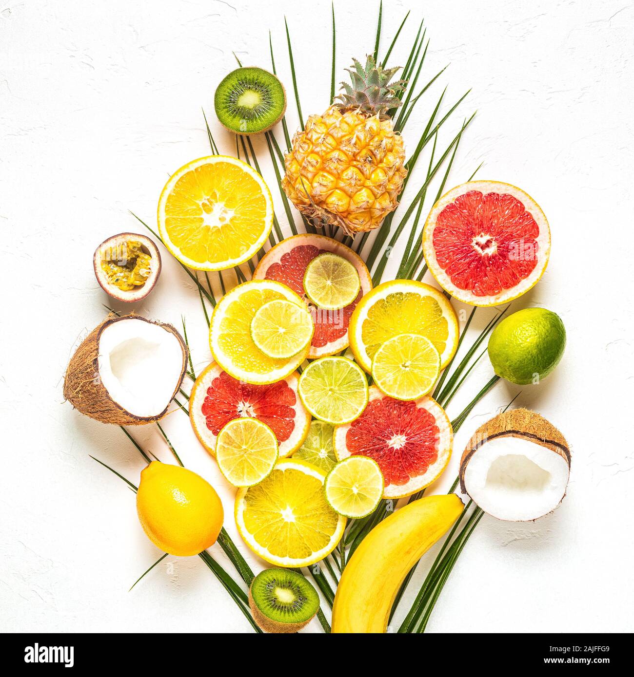 Les fruits tropicaux et de feuilles de palmier sur un fond blanc, vue du dessus. Banque D'Images