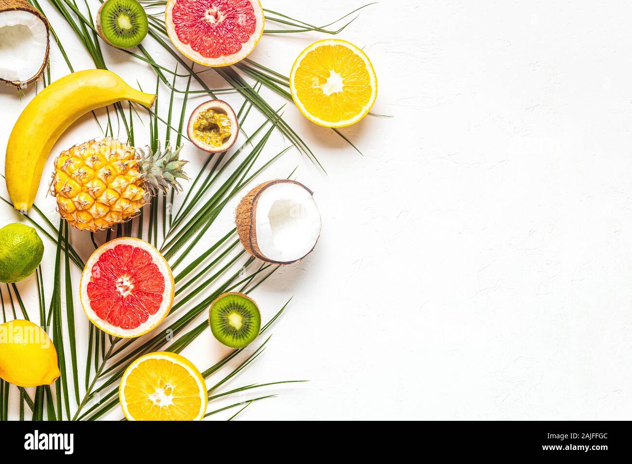 Les fruits tropicaux et de feuilles de palmier sur un fond blanc, vue du dessus. Banque D'Images