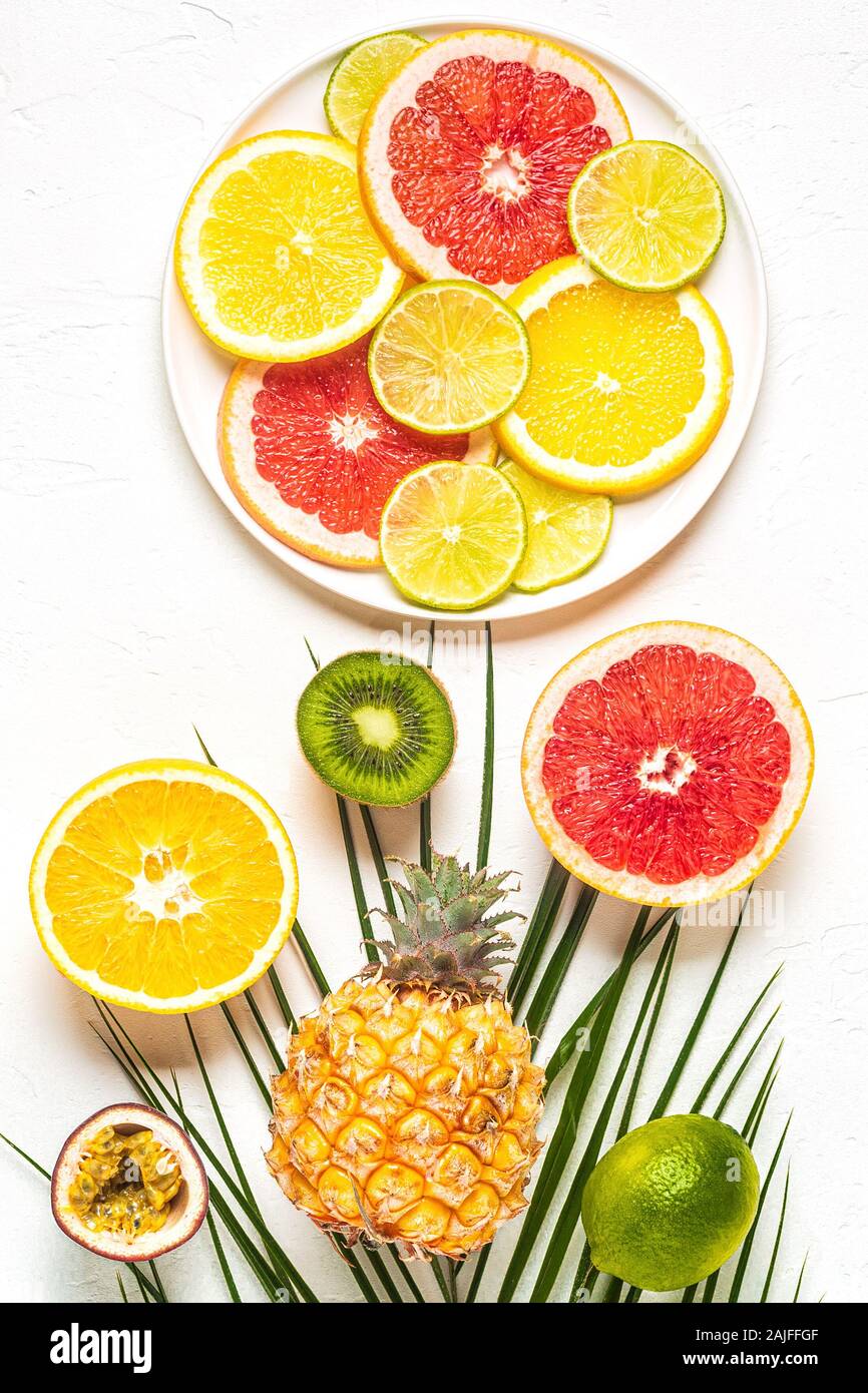Les fruits tropicaux et de feuilles de palmier sur un fond blanc, vue du dessus. Banque D'Images