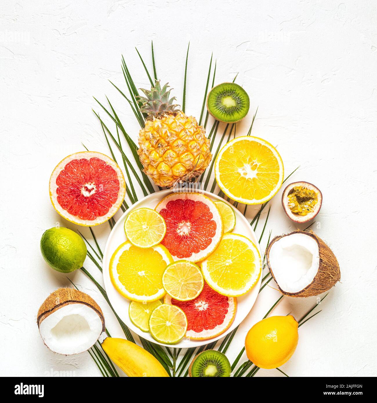 Les fruits tropicaux et de feuilles de palmier sur un fond blanc, vue du dessus. Banque D'Images