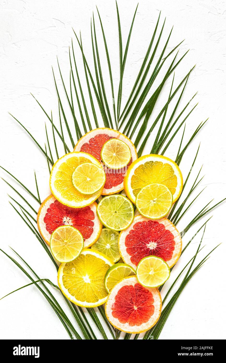 Les fruits tropicaux et de feuilles de palmier sur un fond blanc, vue du dessus. Banque D'Images