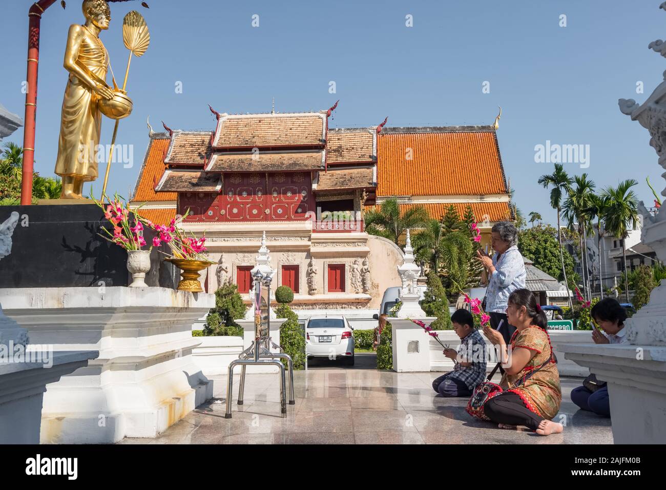 Les thaïs prier en face de Wat Phra Singh temple à Chiang Mai, Thaïlande. Banque D'Images