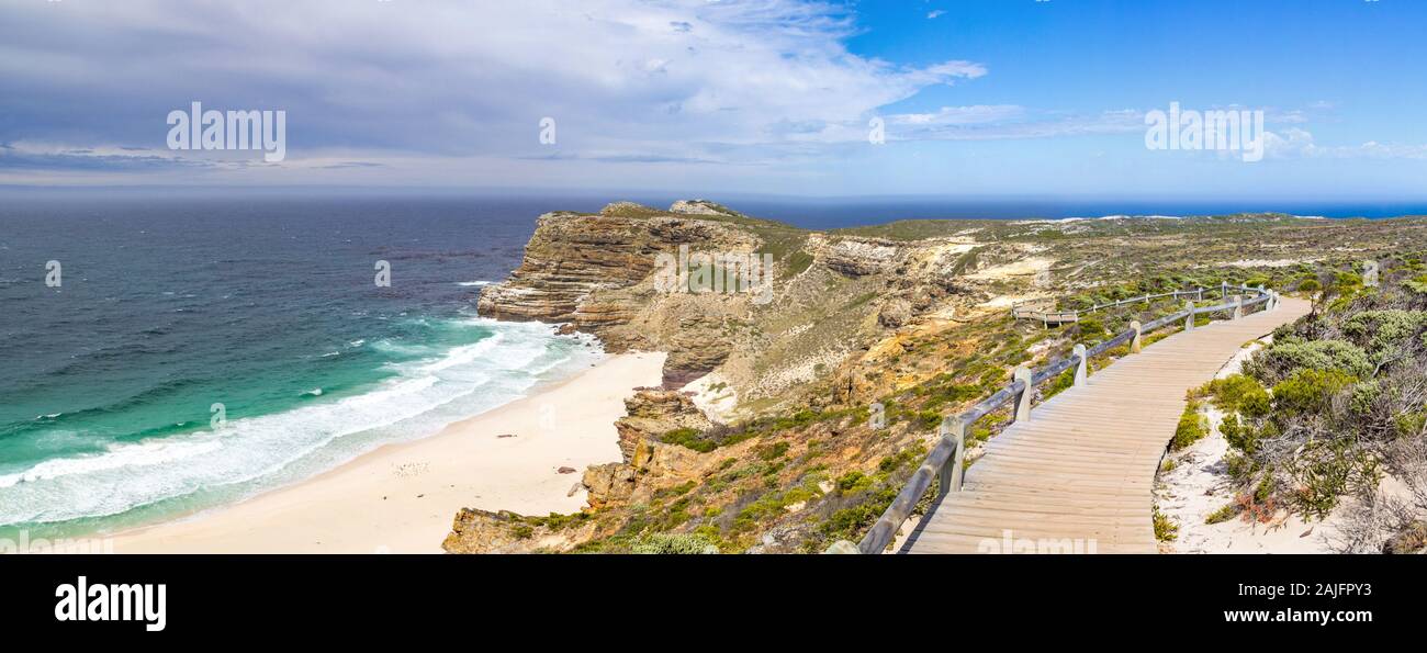 Panorama de la plage de Dias avec passerelle en bois qui traverse la végétation fynbos avec vue sur l'océan par une journée ensoleillée, Cap de Bonne-Espérance, Afrique du Sud Banque D'Images