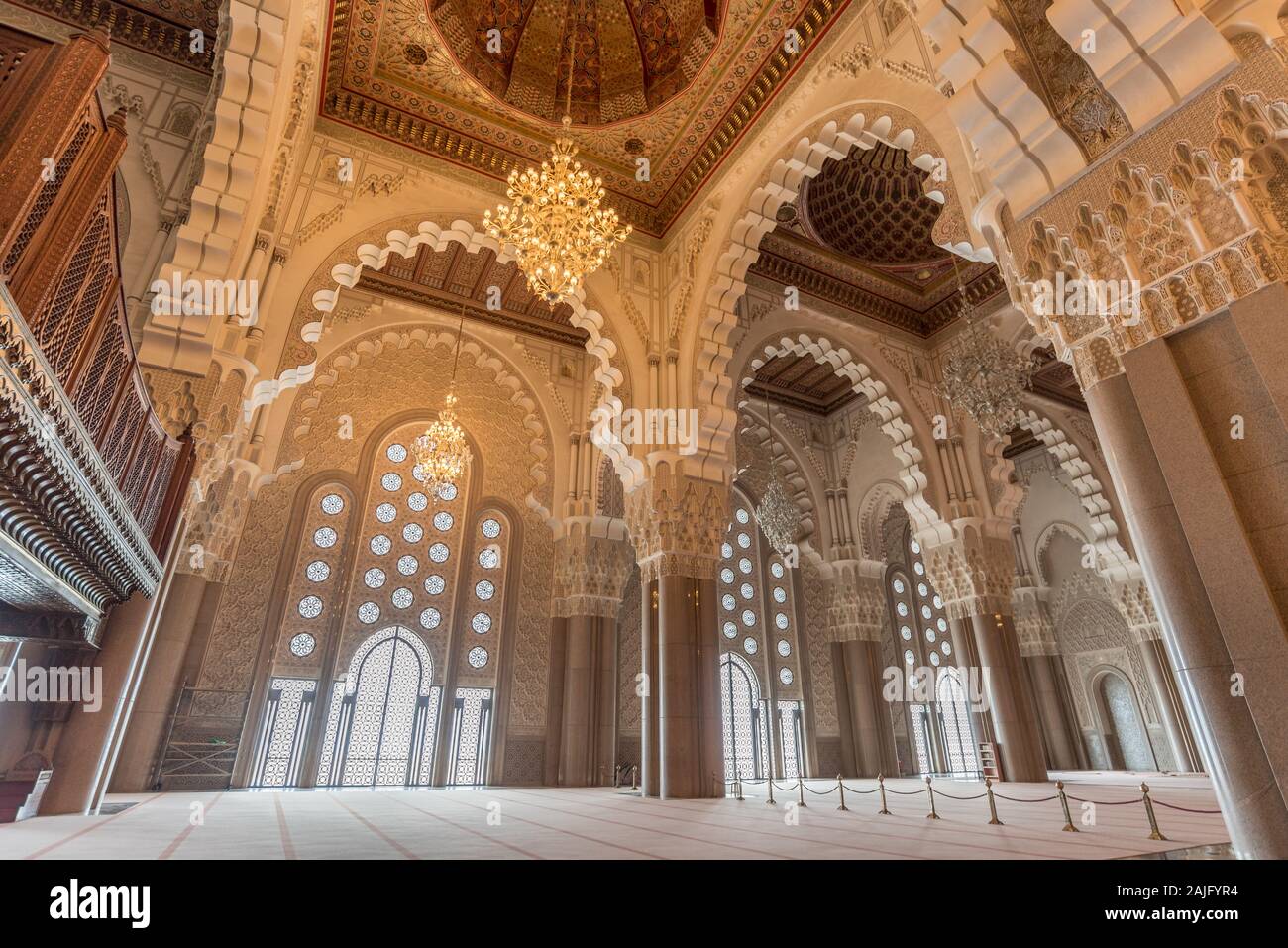 Casablanca, Maroc : l'intérieur (salle de prière) de la Mosquée Hassan II avec des colonnes, des arches et des lustres en verre. L'architecture islamique Banque D'Images