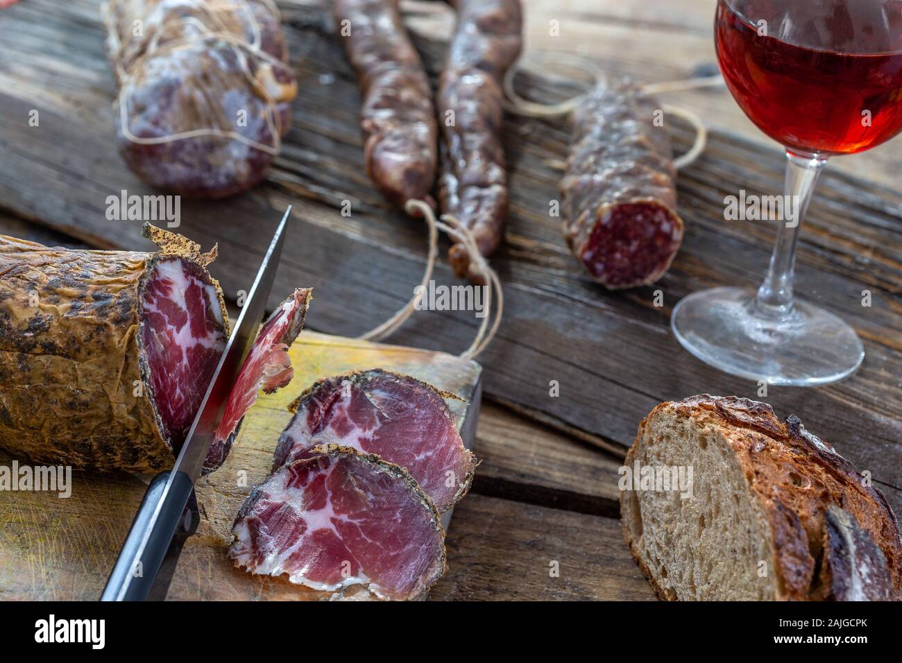 Porc sauvage corse, charcuterie et fromage fabriqué en corse france sur fond de bois avec verre