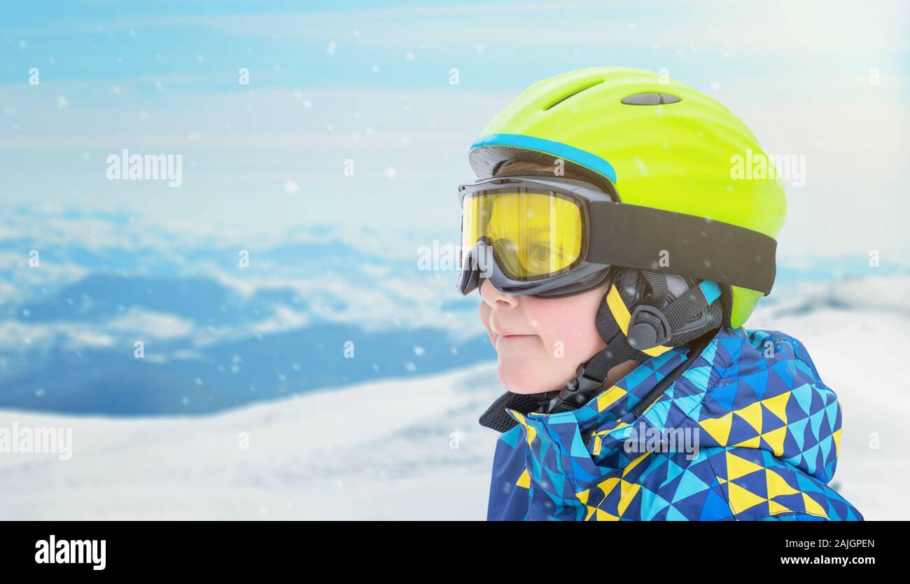 Portrait d'un petit garçon en costume de skieurs, halmet et lunettes de ski montagne. À côté de l'espace de copie Banque D'Images