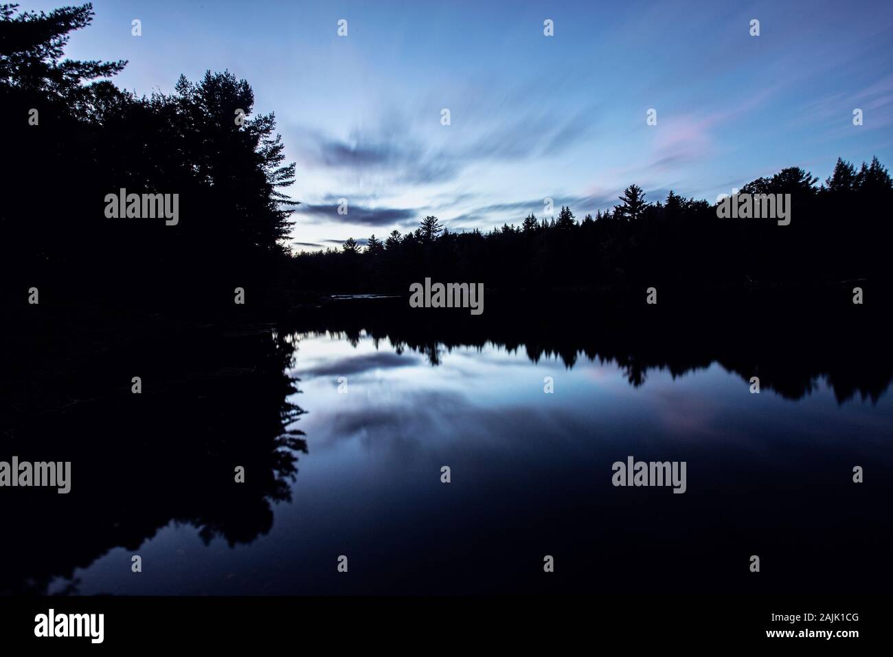 Exposition longue d'arbres en silhouette, rivière Penobscot, Maine au coucher du soleil Banque D'Images