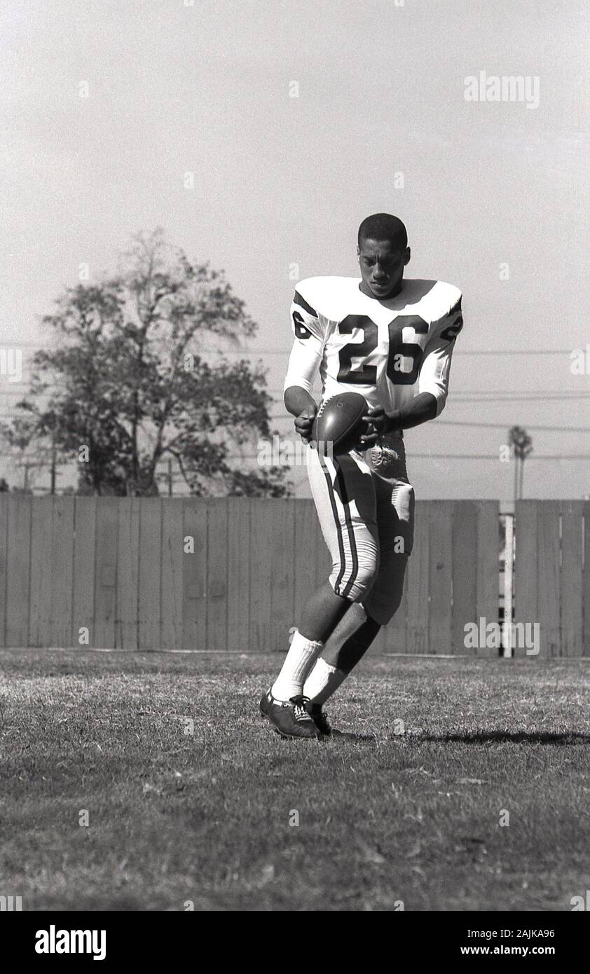 1964, historiques, football américain, homme college student practicising à l'extérieur avec la balle , USA. Banque D'Images
