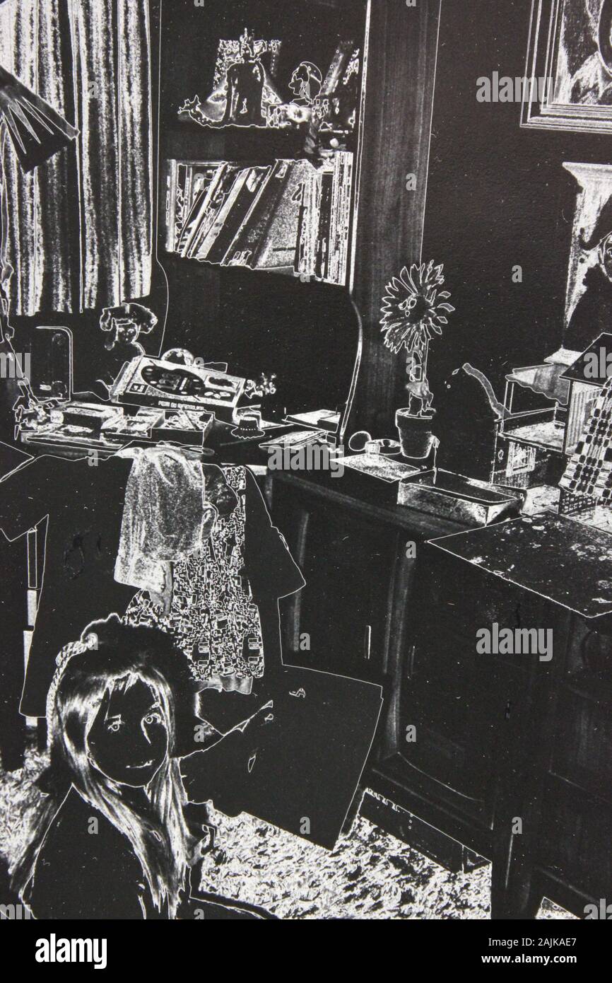 Belle photographie extrême noir et blanc des années 70 d'une fille de dix ans assise dans sa chambre Banque D'Images