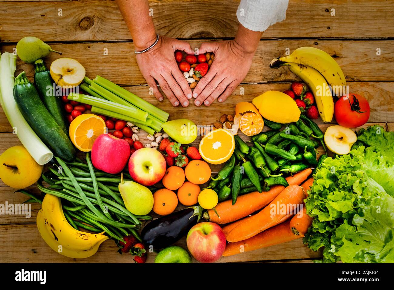 Légumes frais et de saison et de fruits sur une table woodem avec les gens femme mains faisant l'amour avec elle - Foyer de vie sain manger concept pour vegeta Banque D'Images