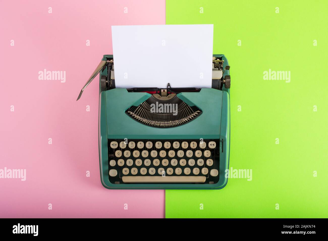 Vintage typewriter avec feuille de papier sur fond vert et rose Banque D'Images