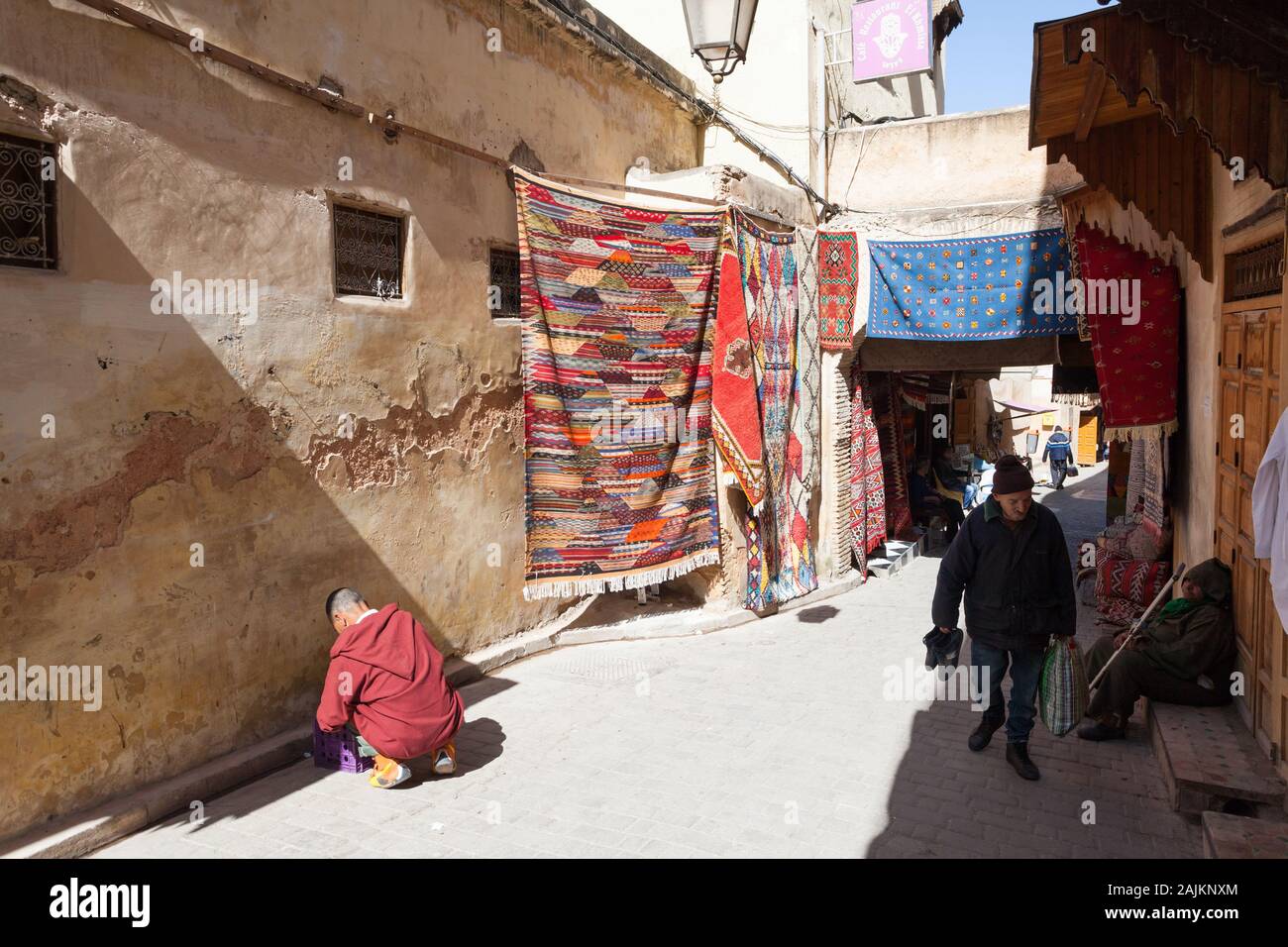 Tapis colorés accrochés dans la rue de Fes El Bali à Fes (également connu sous le nom de Fez), au Maroc Banque D'Images
