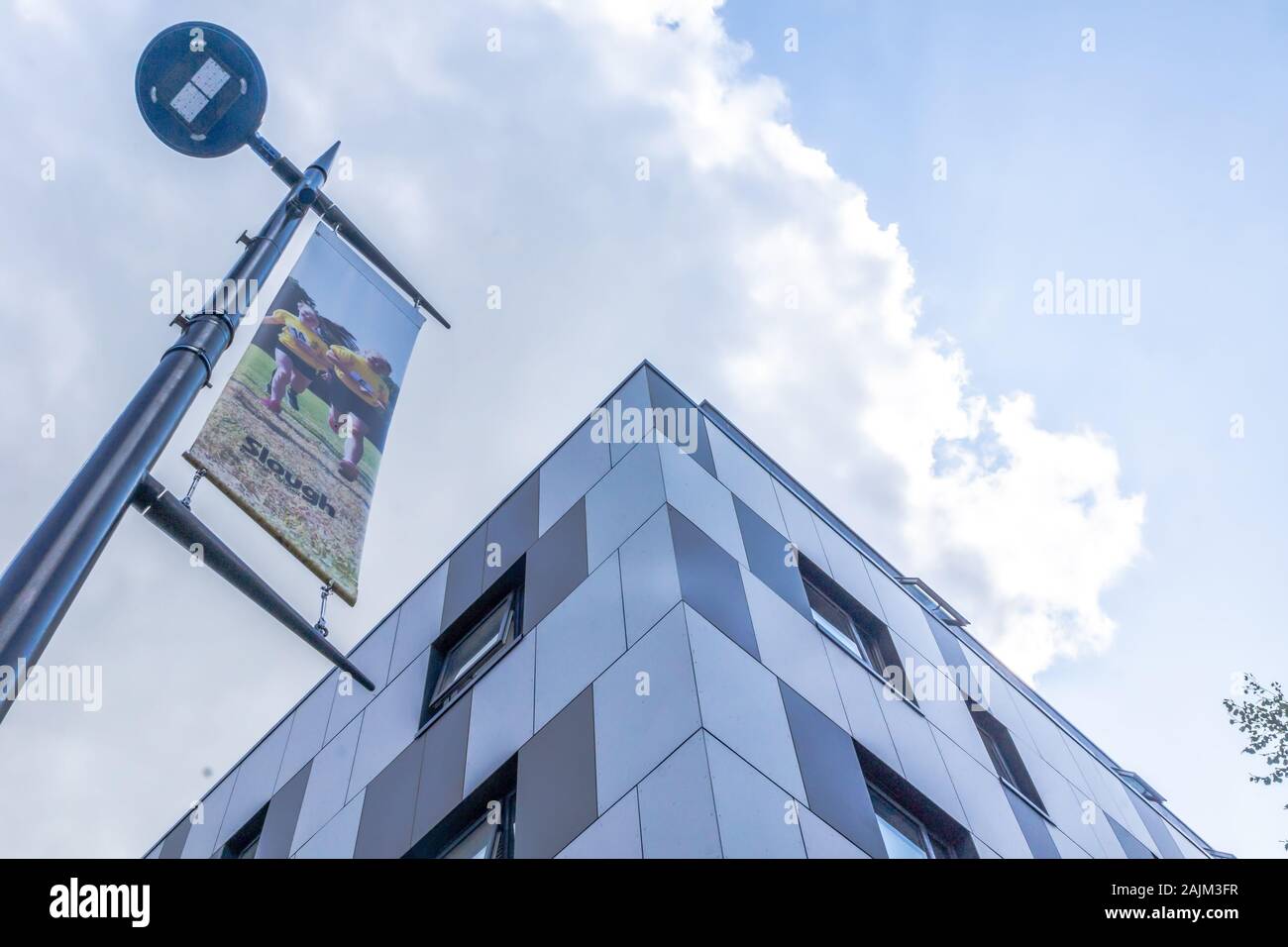 Un bâtiment élevé à Slough, Berkshire, Royaume-Uni. L'architecture moderne. Les tons de bleu panneaux à damiers. Signer avec un deux coureurs étiqueté 'Slough'. Banque D'Images