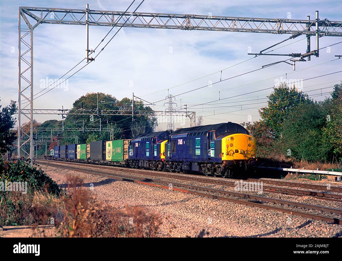 Une paire de locomotives diesel de la classe 37 DRS travaillant un service intermodal à Easenhall sur la côte ouest de Mainline. Banque D'Images