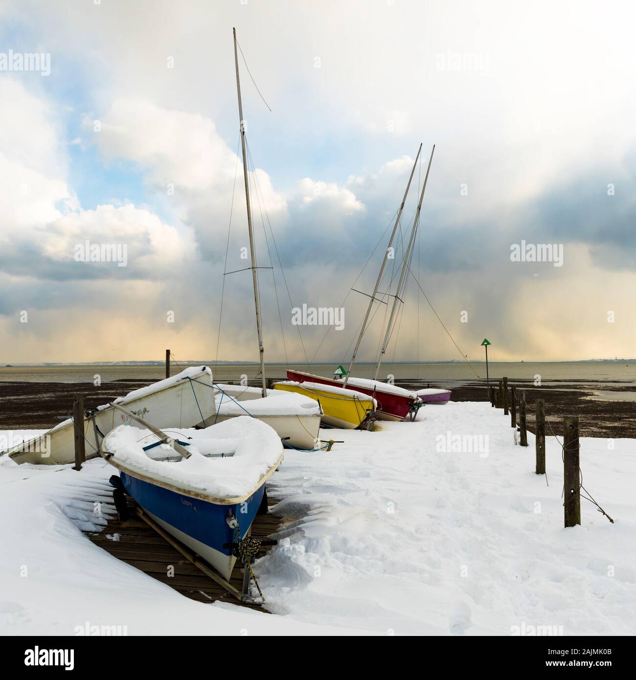 Les petits bateaux dans la neige avec de l'eau dans le fond et moody sky Banque D'Images