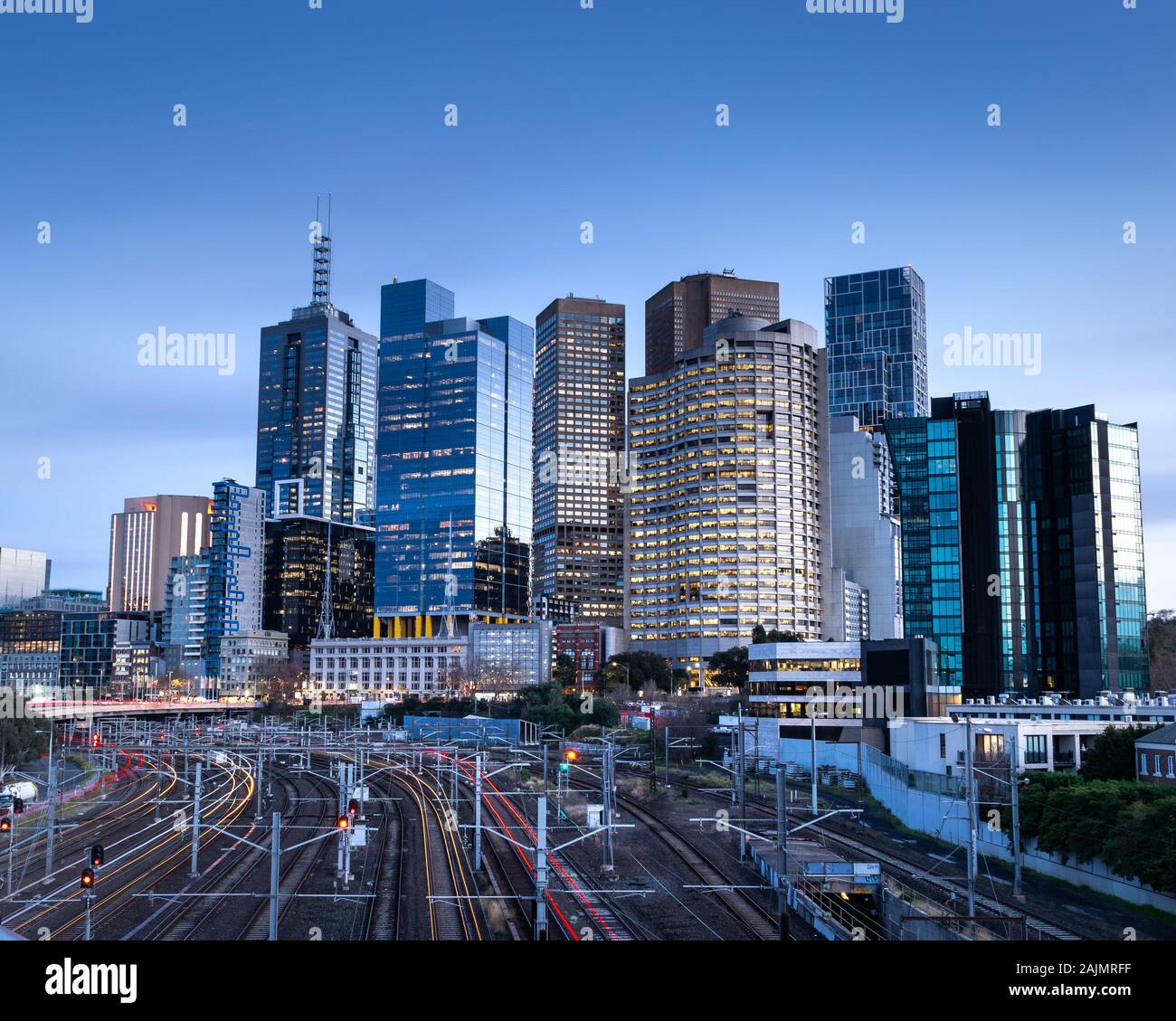 Des sentiers de lumière sur la voie ferrée qui nous conduit vers les toits de Melbourne. Banque D'Images