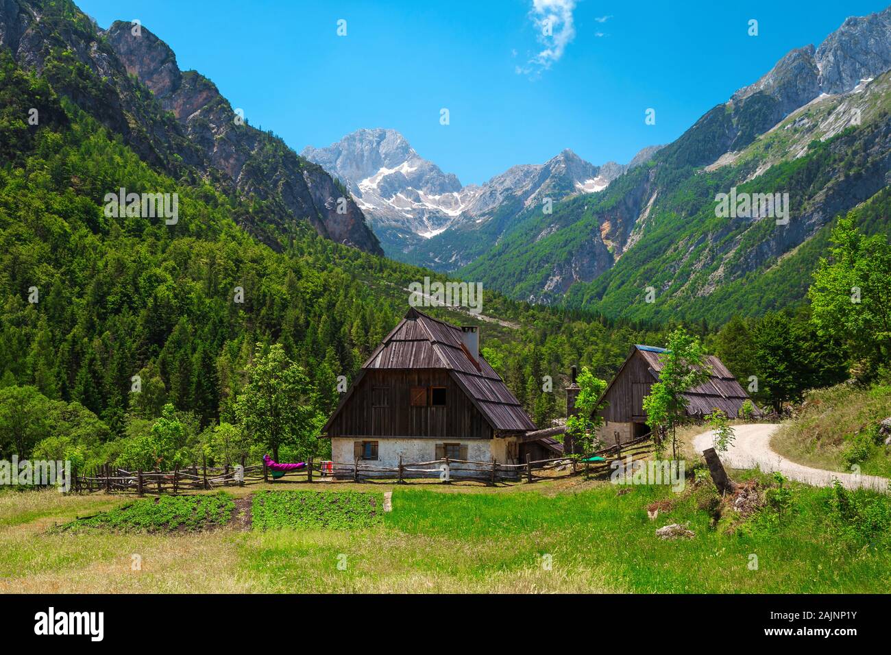 L'été pittoresque paysage alpin avec des maisons de campagne et de hautes montagnes enneigées en arrière-plan, la vallée de la soca, Slovénie, Europe Banque D'Images