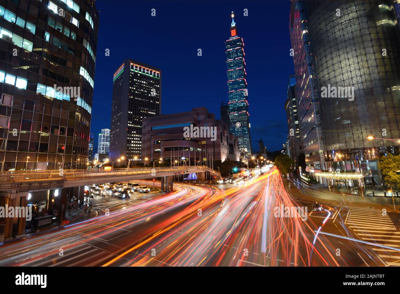 TAIPEI, TAIWAN - Le 15 août 2016 - Red light trails de la circulation routière à travers strie une intersection achalandée en face de Taipei 101 Banque D'Images