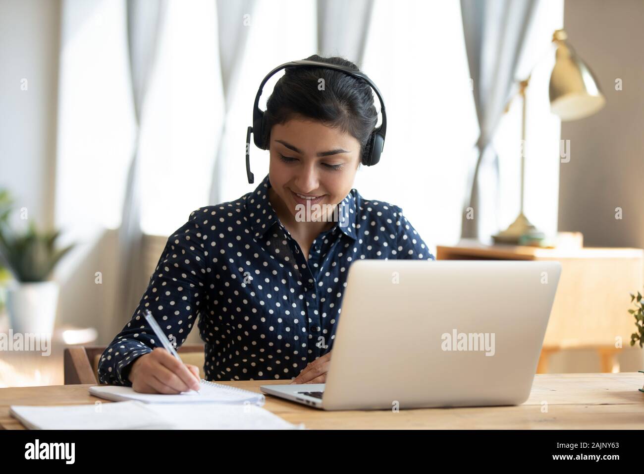 Indian girl casque usure étudiant enseignant en ligne étude écrire des notes Banque D'Images