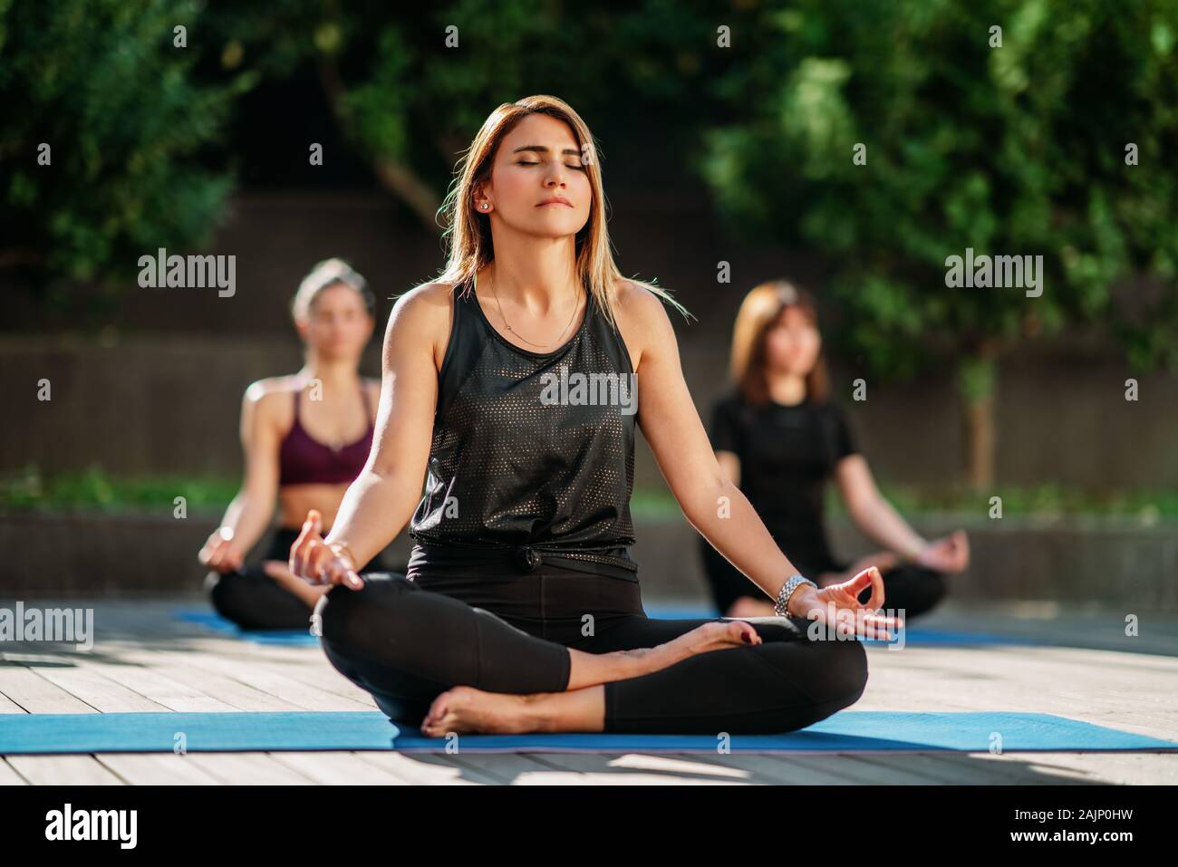 Vue sur les femmes face à la relaxation le yoga dans le jardin. Banque D'Images