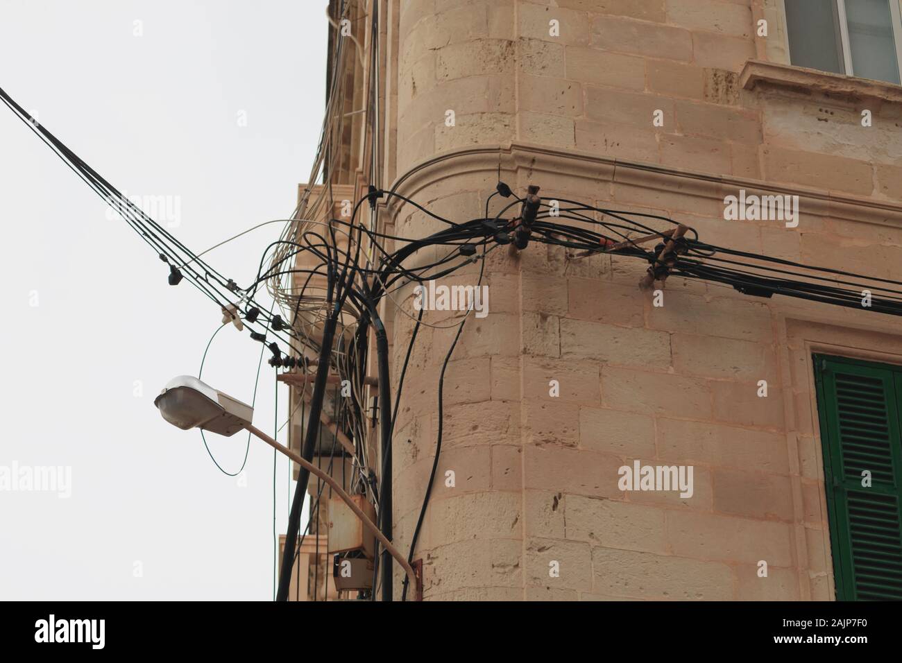 Les câbles électriques en désordre sur le coin de mur à Malte Banque D'Images