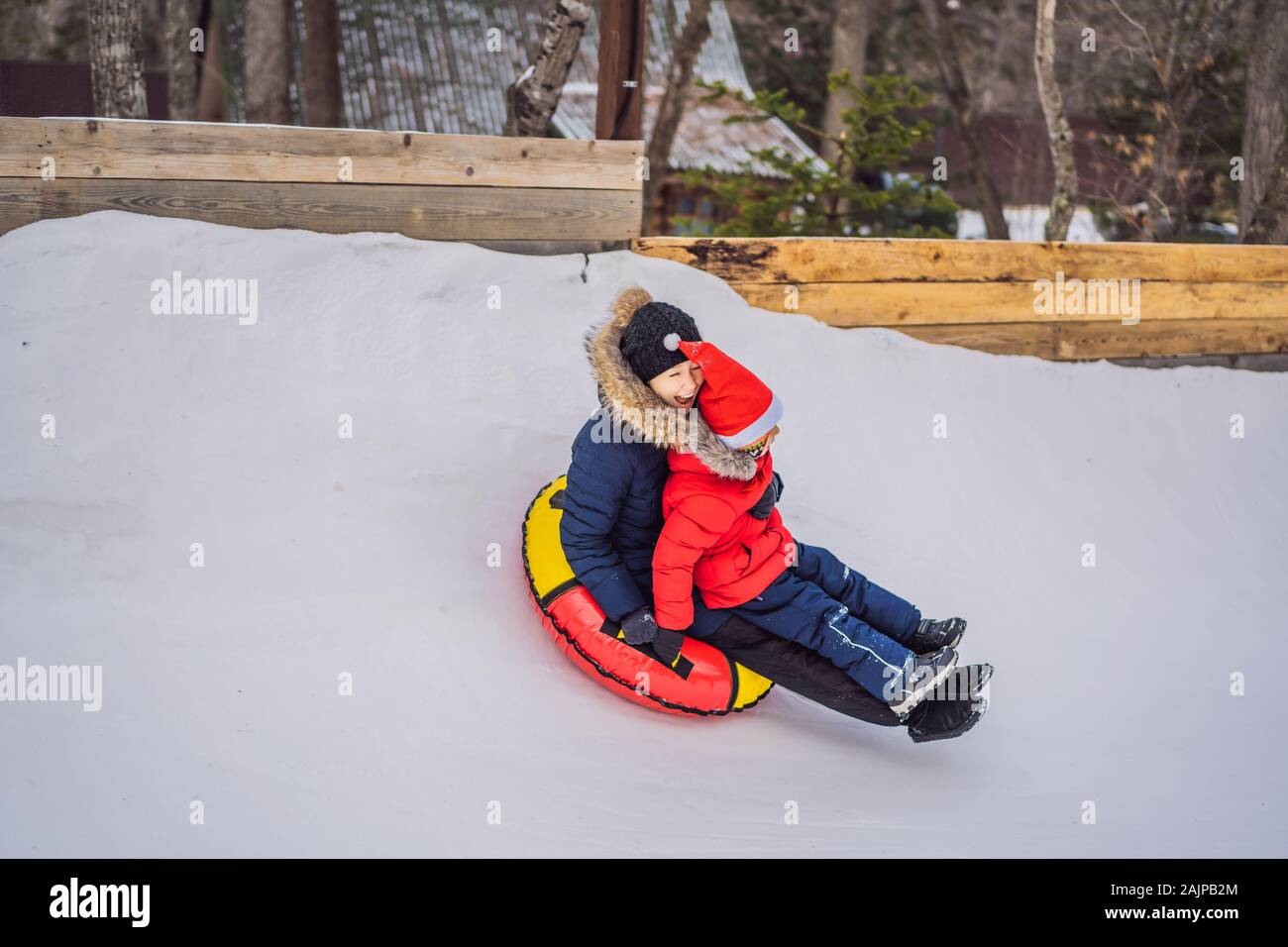 Maman fils monter sur une luge hiver gonflable tube. Plaisir d'hiver pour  toute la famille Photo Stock - Alamy