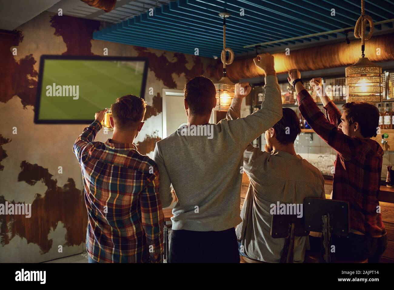 Un groupe d'amis de regarder la télévision au football dans un bar sportif. Banque D'Images