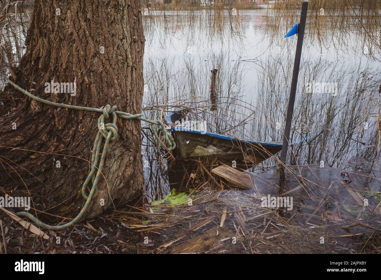 Un bateau à rames est situé sur la rive d'un petit lac gelé Banque D'Images