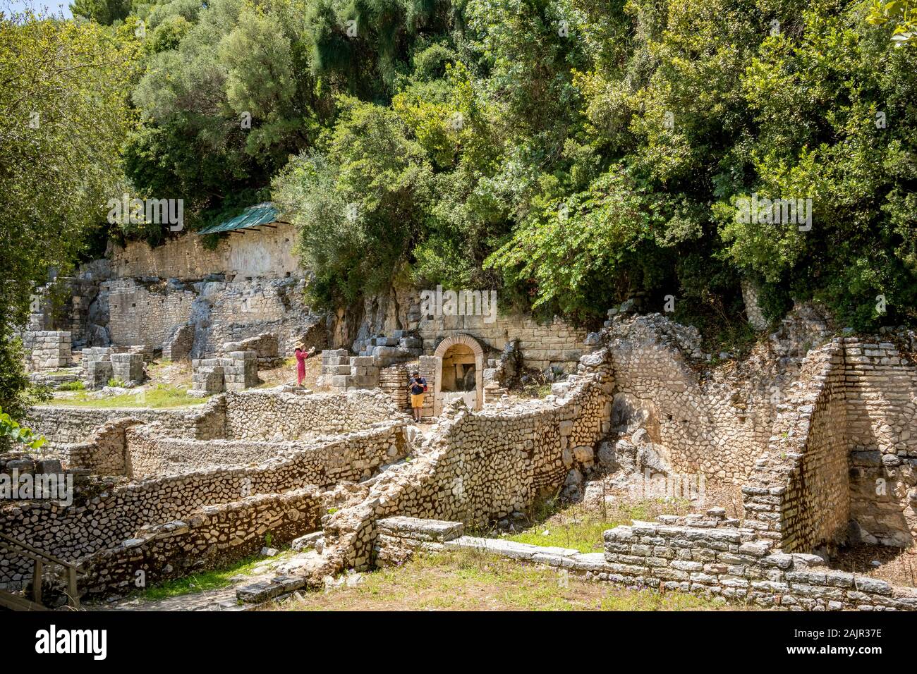 BUTRINT, ALBANIE - 7 juin 2019 : les touristes regarder et prendre des photos des ruines, de palais central. Belle journée de printemps chaude site archéologique au patrimoine de l'Albanais. Avec la photographie de la flore vert frais Banque D'Images