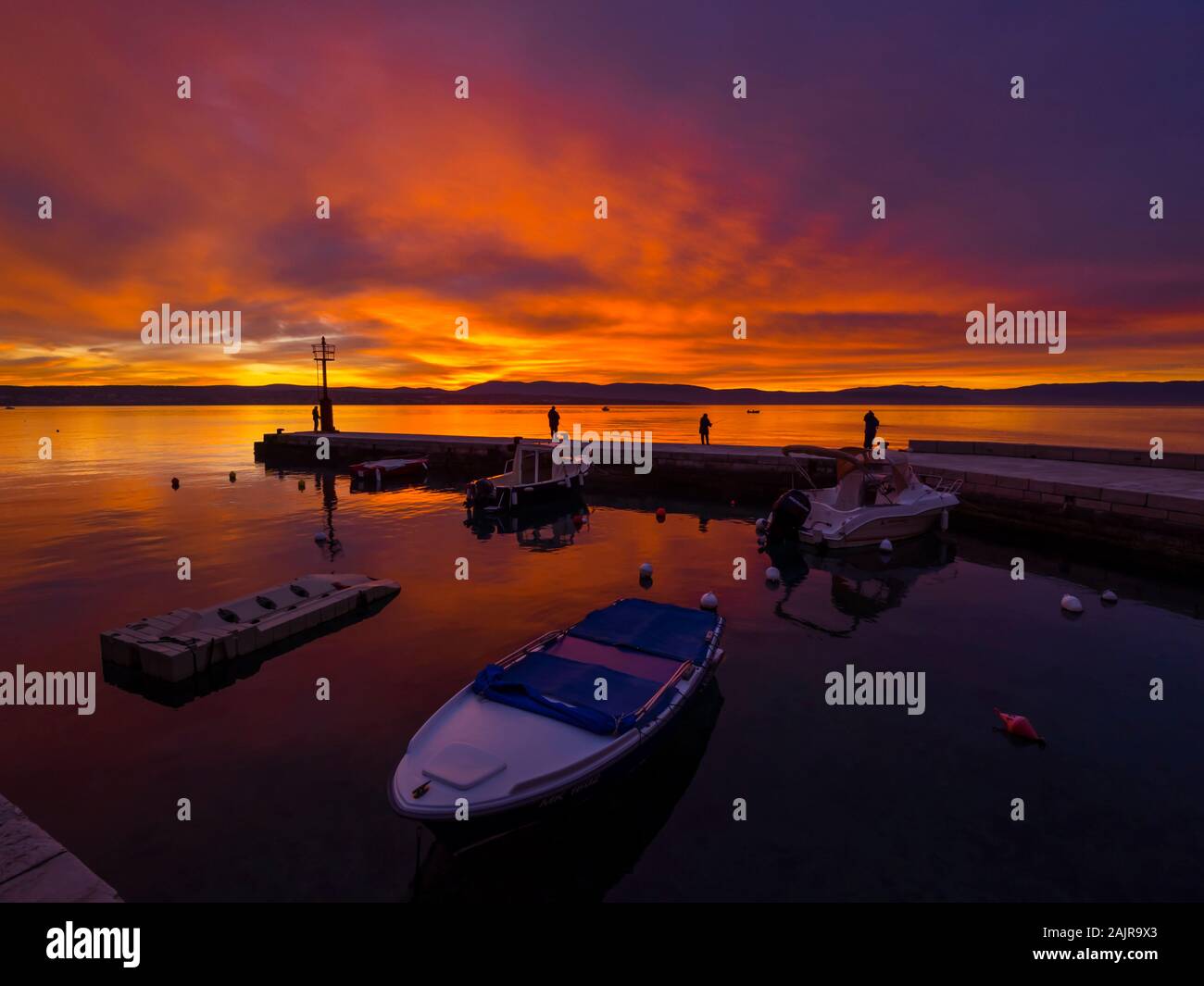 Les pêcheurs avant le coucher du soleil paysage dans petit port à Malinska en Croatie l'atmosphère paisible ciel glorieux seawall Ribarsko selo Haludovo Kvarner Banque D'Images
