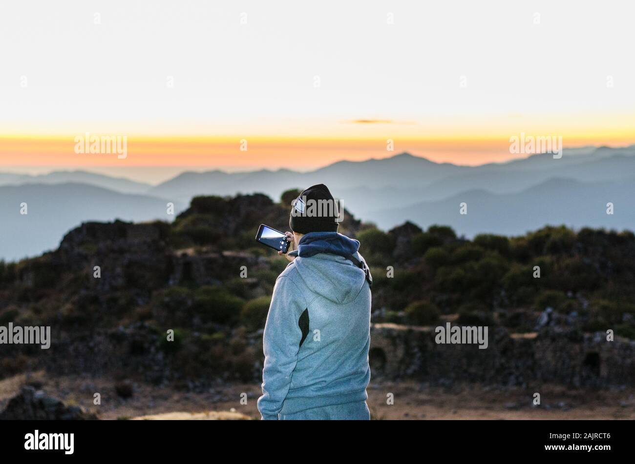 Jeune randonneur avec un smartphone sur le dessus de la montagne pic en Chiprac, Lima - Pérou Banque D'Images