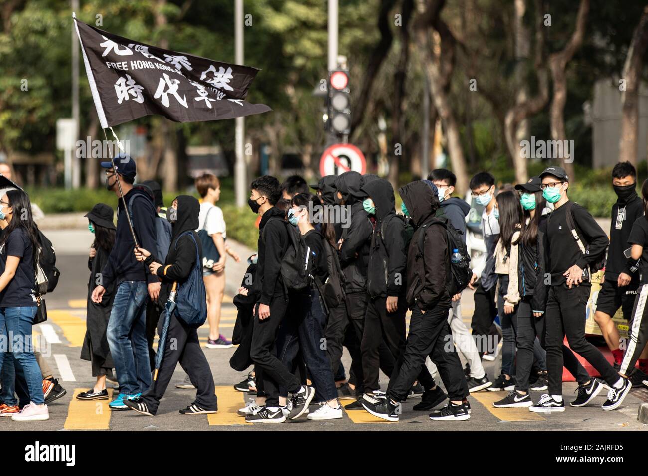 Les manifestants avec des drapeaux de traverser la rue pendant la manifestation.dimanche à Sheung Shui contre le commerce parallèle, ils demandent aux autorités de prendre des mesures à l'encontre des opérateurs parallèles qui de stock dans les boutiques locales puis tourner autour de les vendre pour le profit de l'autre côté de la frontière. Plusieurs de ces marches ont vu depuis Hong Kong manifestations ont commencé en juin et ressemblent souvent à des rassemblements anti-gouvernementaux. Banque D'Images