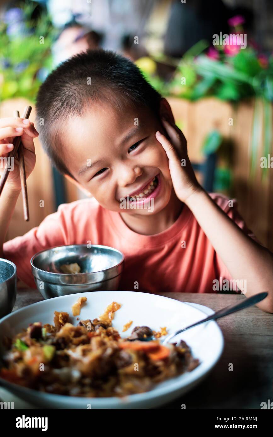 Cute Asian enfant déjeunant au restaurant Banque D'Images