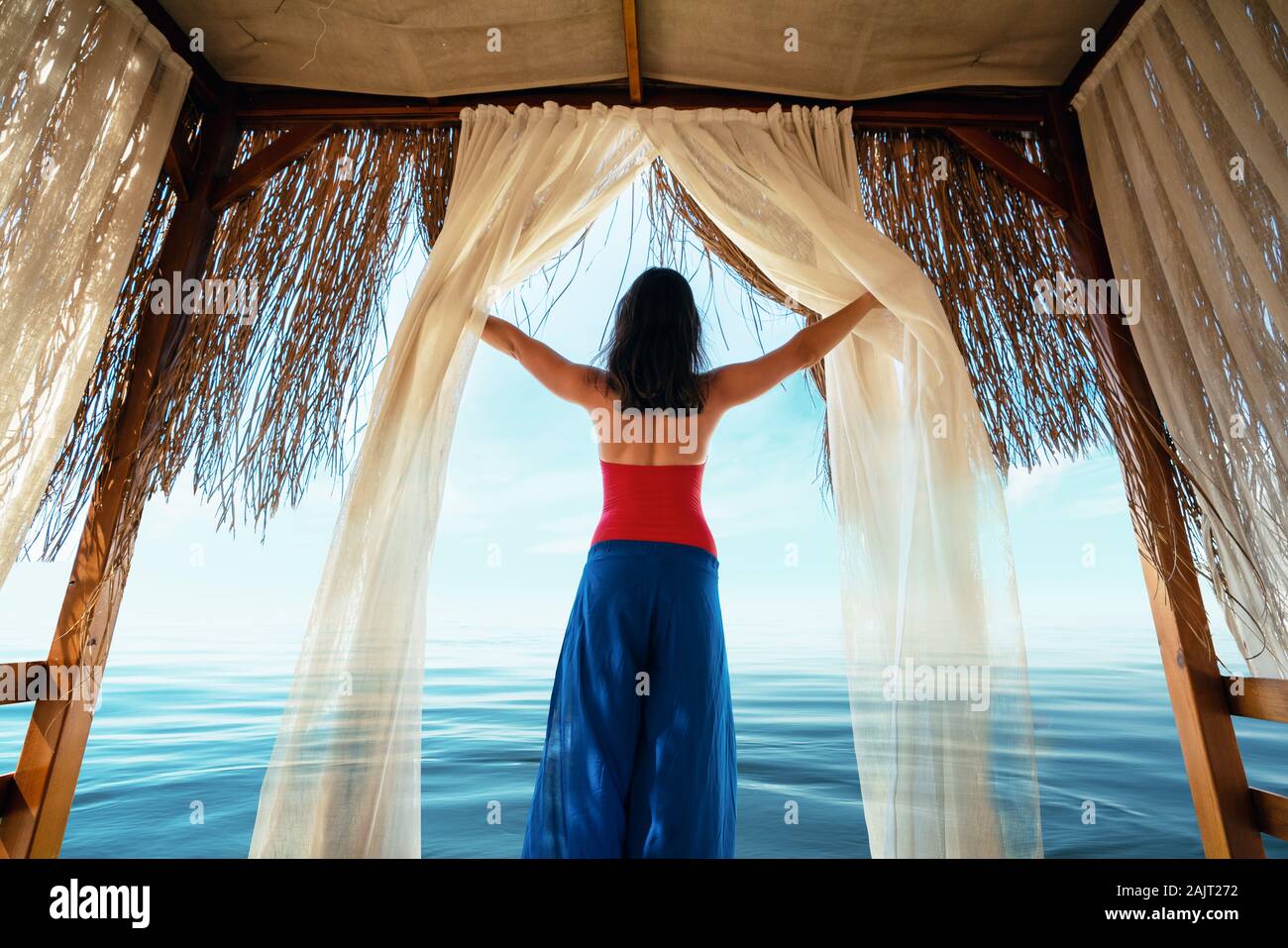 Jeune femme se détendre dans une pergola en vacances près de la mer. Banque D'Images