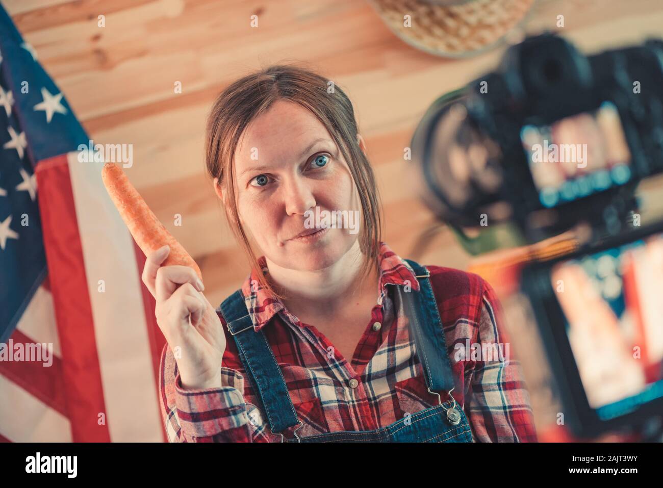 La productrice de médias sociaux vidéo vlog à propos de travaux agricoles saisonniers et l'activité agricole, femme vêtue comme travailleur agricole à l'avant de l'appareil t Banque D'Images