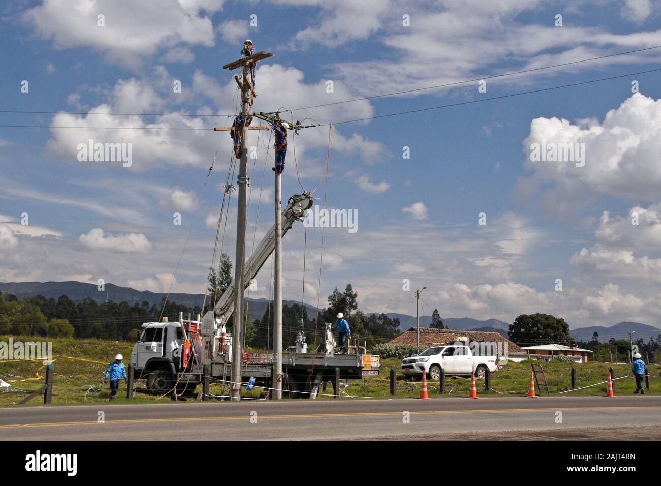 Remplacement de poseurs de pôle et l'exécution de fils électriques en zone rurale de Colombie Banque D'Images