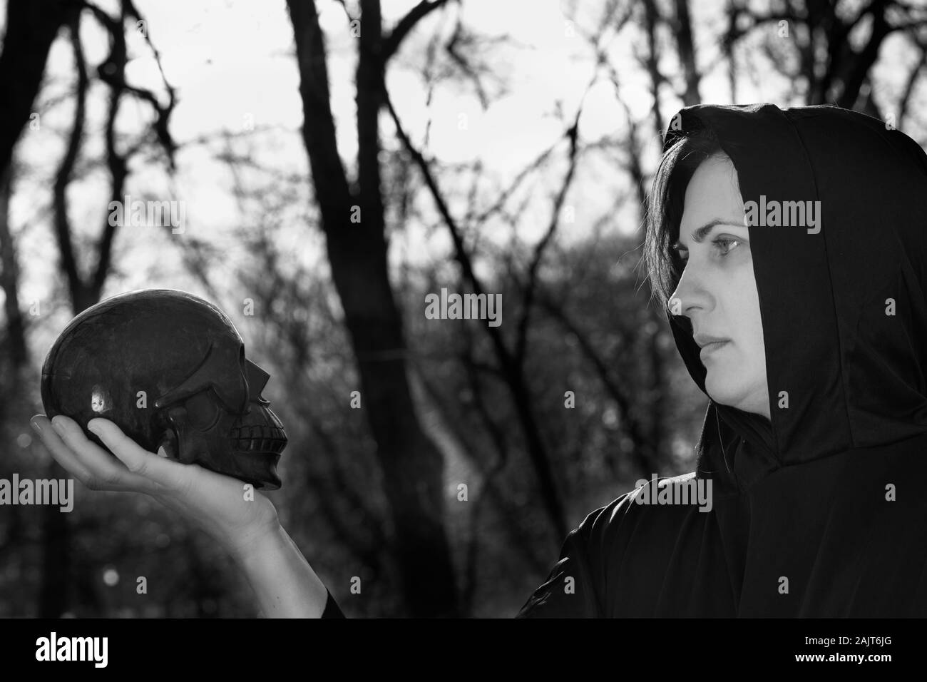 Sweats femme en robe noire profondément dans la forêt. Des sorcières. Et l'Halloween concept gothique. La sorcellerie et la magie. Effrayant. Banque D'Images