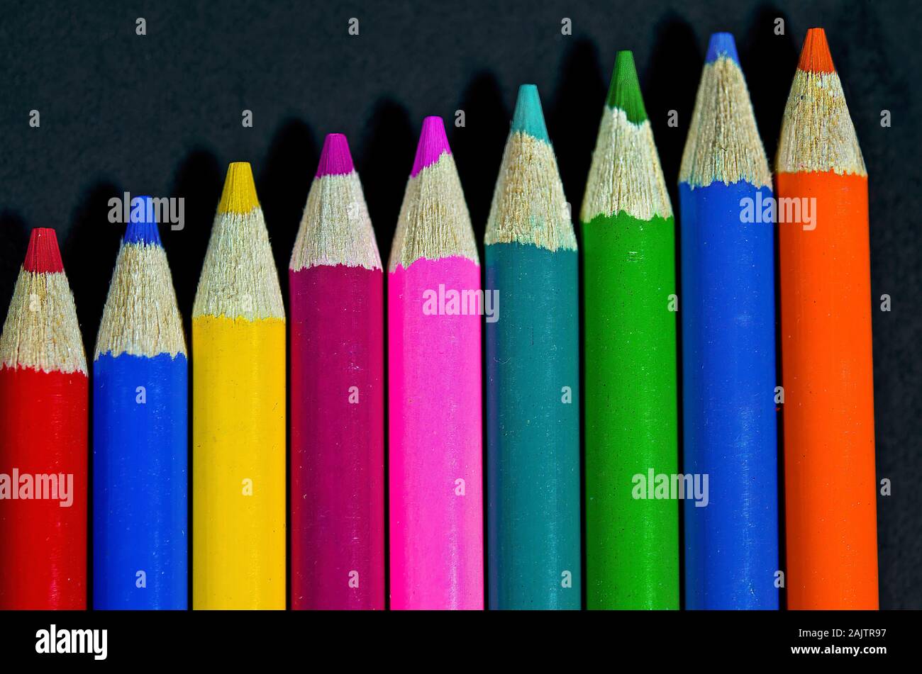 Close up de la rangée de crayons de couleur sur fond noir Banque D'Images