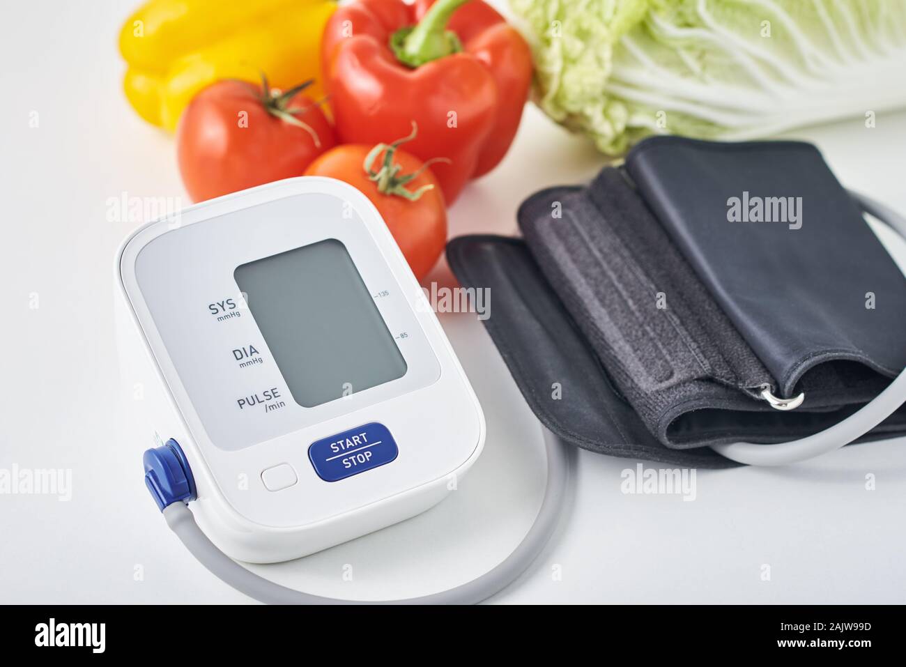 Tensiomètre numérique et des légumes frais sur la table. Concept de soins de santé Banque D'Images
